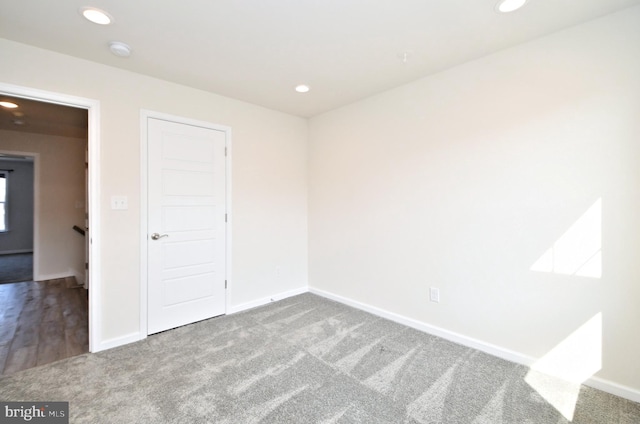 carpeted spare room featuring recessed lighting and baseboards