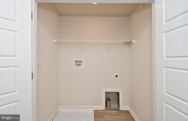 clothes washing area with electric dryer hookup, washer hookup, wood finished floors, baseboards, and laundry area