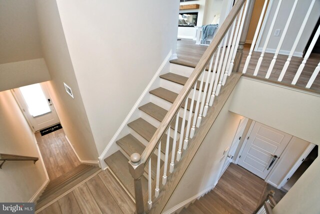 staircase featuring wood finished floors and baseboards