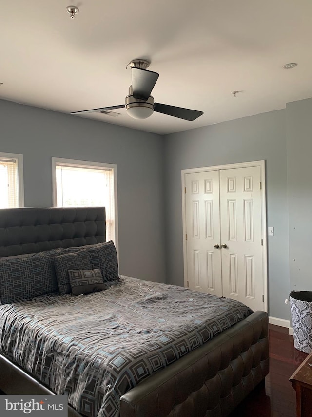 bedroom with ceiling fan, multiple windows, and a closet