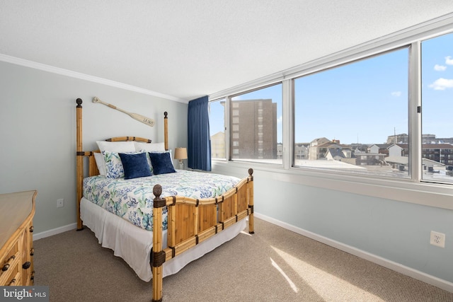 carpeted bedroom with ornamental molding and baseboards