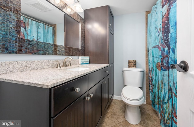 bathroom with visible vents, toilet, vanity, tile patterned flooring, and baseboards