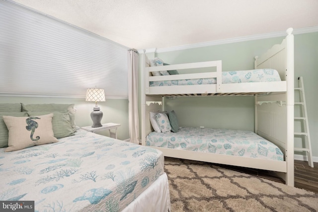 bedroom with crown molding and wood finished floors