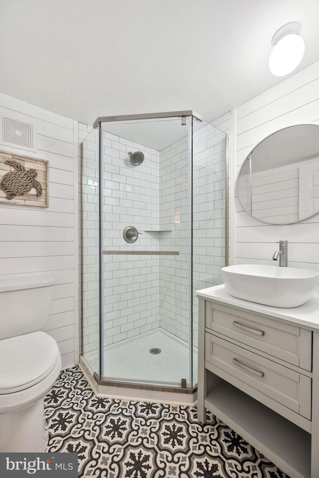 full bath featuring toilet, a stall shower, tile patterned floors, and vanity