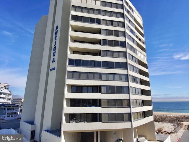 view of property with a water view and a view of the beach