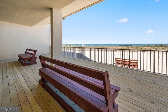 wooden terrace with a view of the beach and a water view