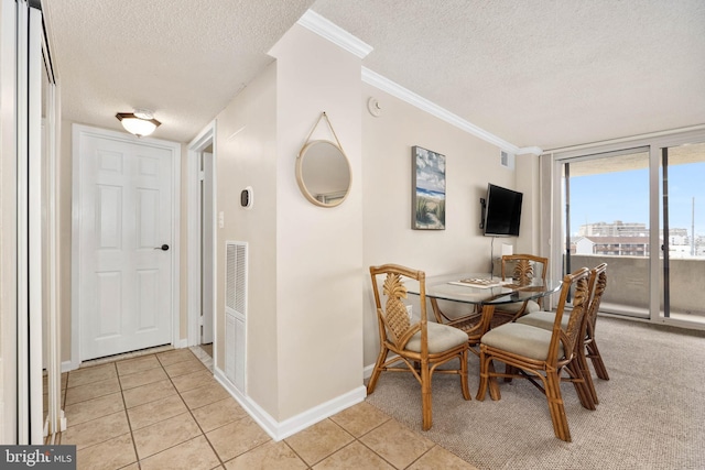 dining room featuring light tile patterned floors, ornamental molding, a textured ceiling, and visible vents