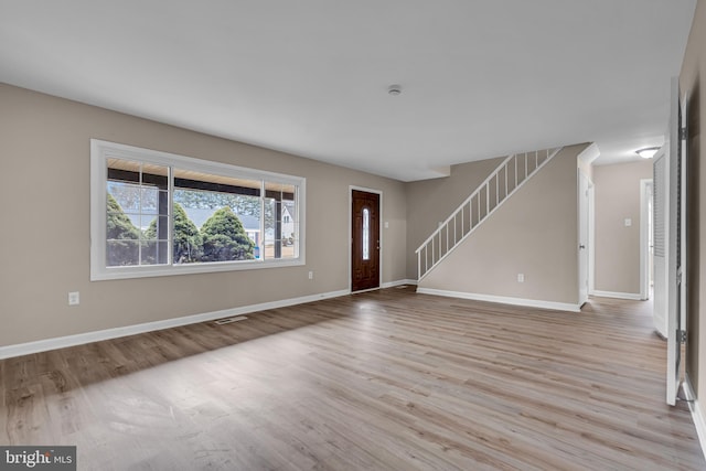 entryway featuring visible vents, stairs, baseboards, and wood finished floors