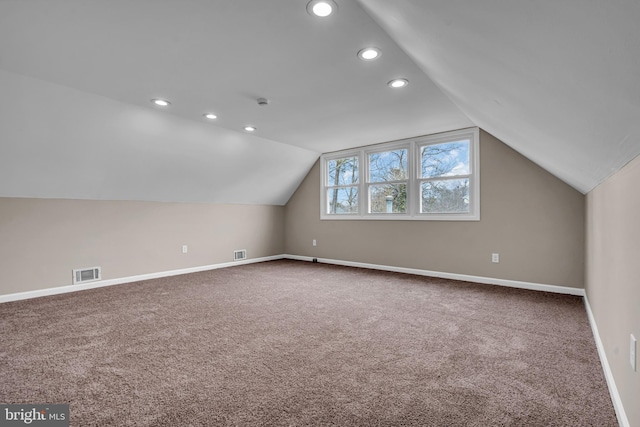 bonus room with carpet floors, visible vents, vaulted ceiling, and baseboards