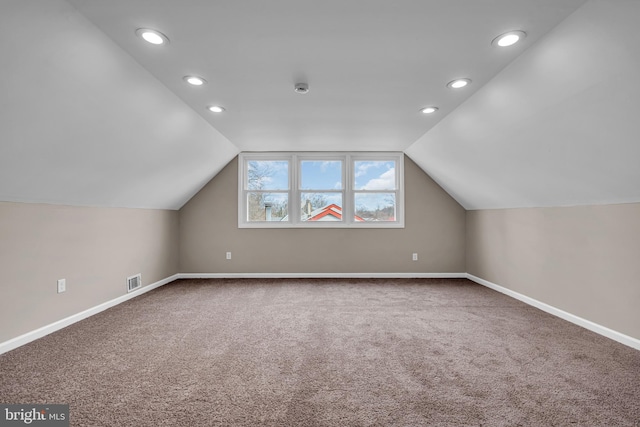 additional living space featuring carpet floors, recessed lighting, visible vents, vaulted ceiling, and baseboards