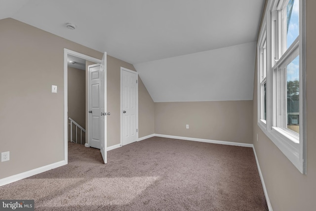 additional living space with carpet, vaulted ceiling, and baseboards