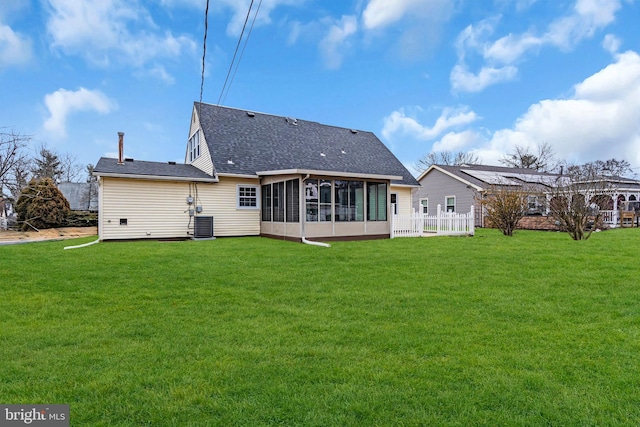 back of property with a yard, a shingled roof, fence, and a sunroom