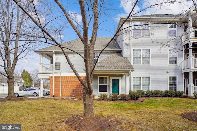 view of front of property with a shingled roof and a front lawn