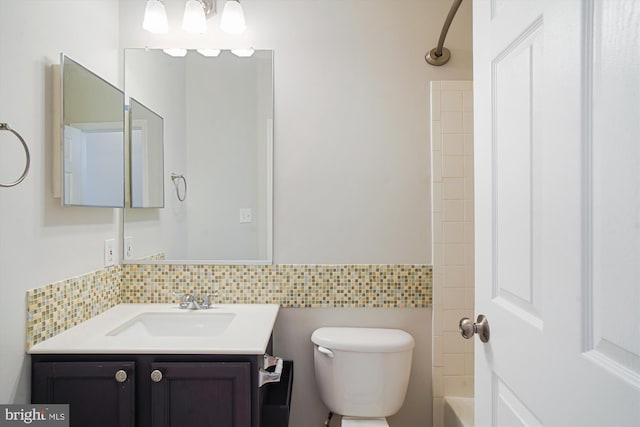 bathroom featuring toilet, washtub / shower combination, vanity, and decorative backsplash