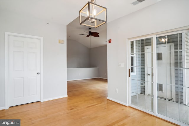 unfurnished room with a ceiling fan, visible vents, baseboards, and wood finished floors