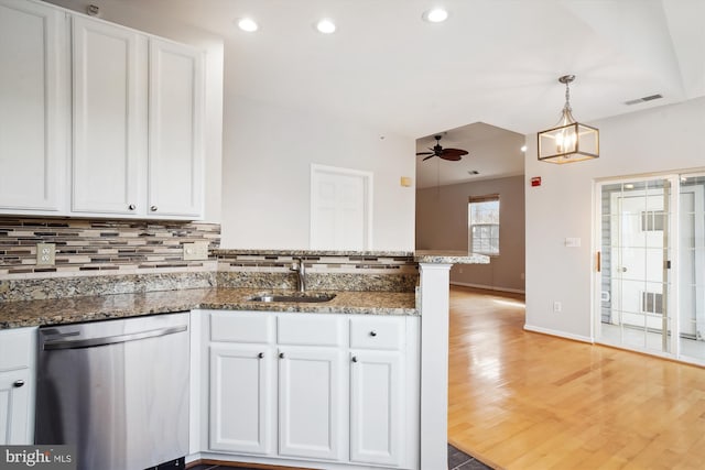 kitchen featuring a peninsula, a sink, white cabinetry, decorative backsplash, and dishwasher