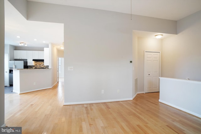 empty room featuring light wood-style floors, visible vents, and baseboards