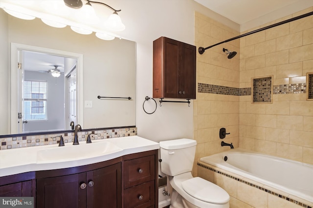 bathroom with toilet, tiled shower / bath, backsplash, and vanity