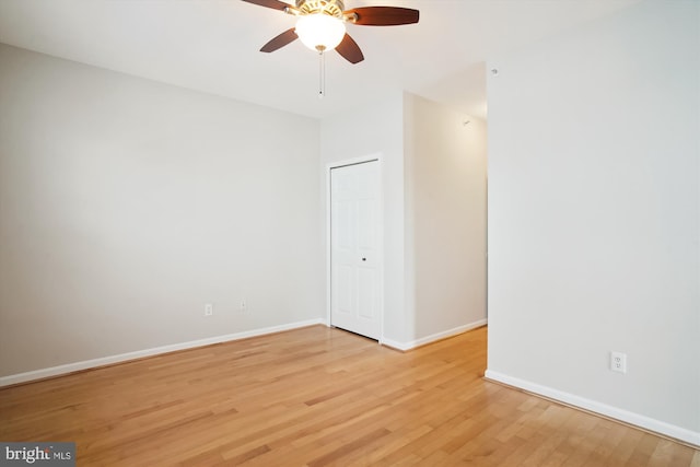 spare room with light wood-style floors, ceiling fan, and baseboards