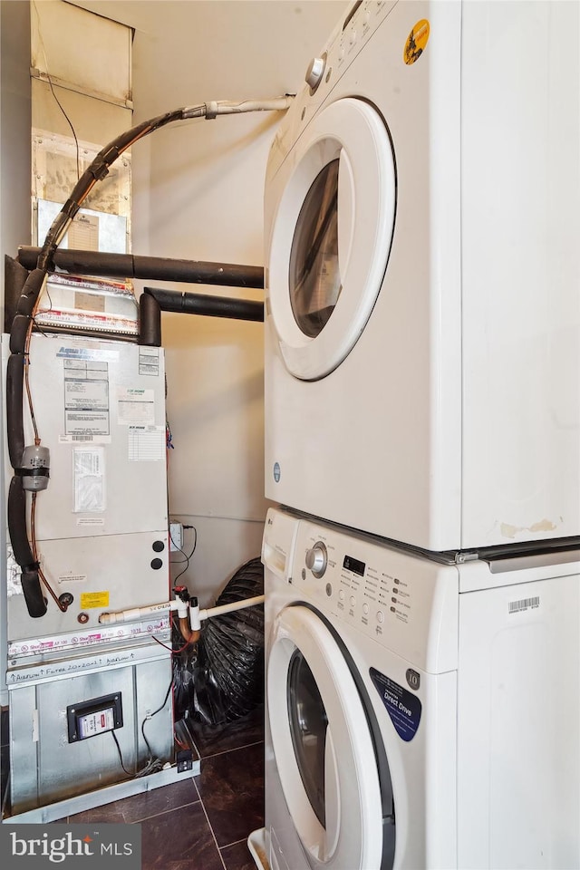 clothes washing area with laundry area and stacked washer / drying machine