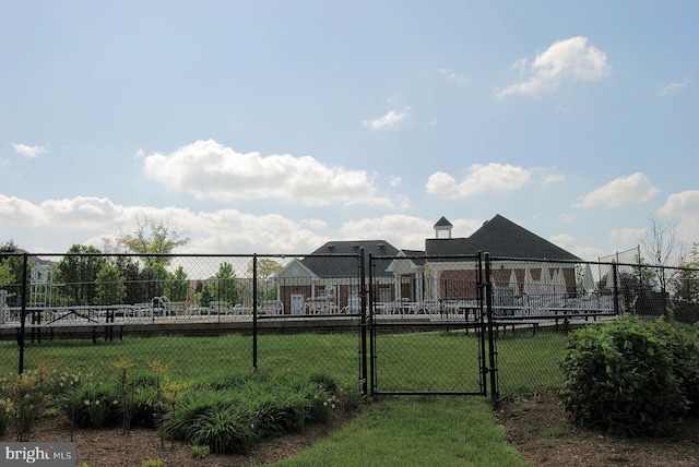 exterior space featuring a gate, fence, and a front lawn