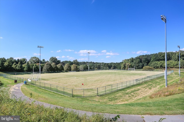 view of community with fence, a view of trees, and a rural view