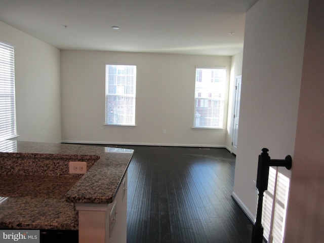 unfurnished room featuring dark wood-style floors and baseboards