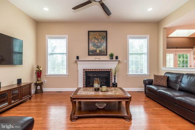 living area with hardwood / wood-style flooring, recessed lighting, a fireplace, and baseboards