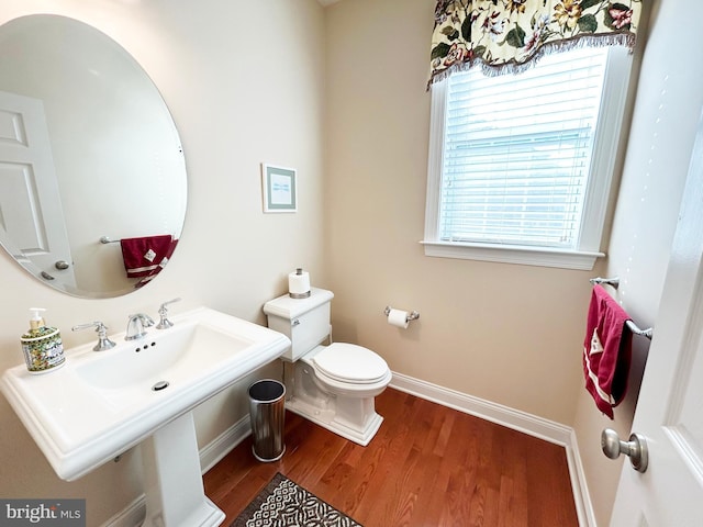 bathroom featuring a sink, baseboards, toilet, and wood finished floors