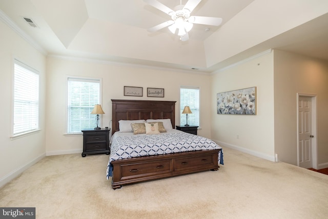 bedroom featuring baseboards, light carpet, a raised ceiling, and visible vents