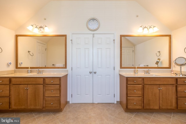 full bathroom with lofted ceiling, two vanities, and a sink