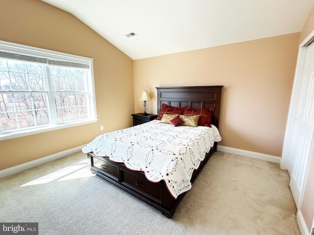 bedroom featuring visible vents, baseboards, light colored carpet, and vaulted ceiling