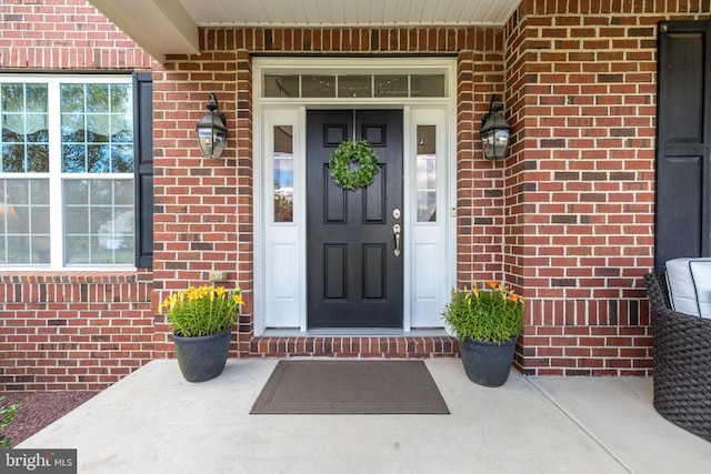 doorway to property featuring brick siding