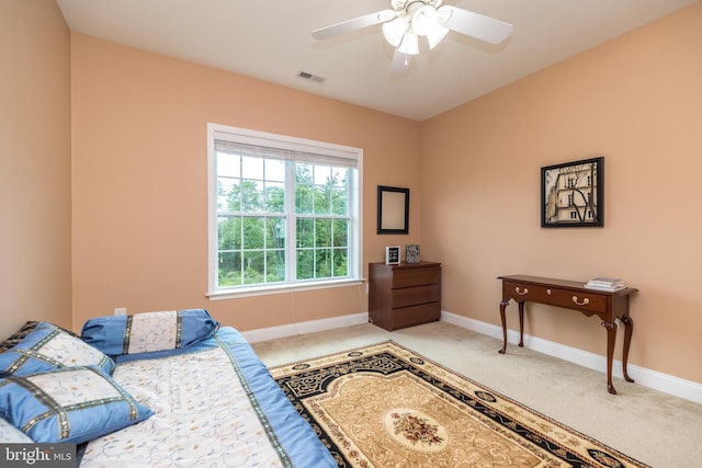 bedroom with a ceiling fan, baseboards, visible vents, and light carpet