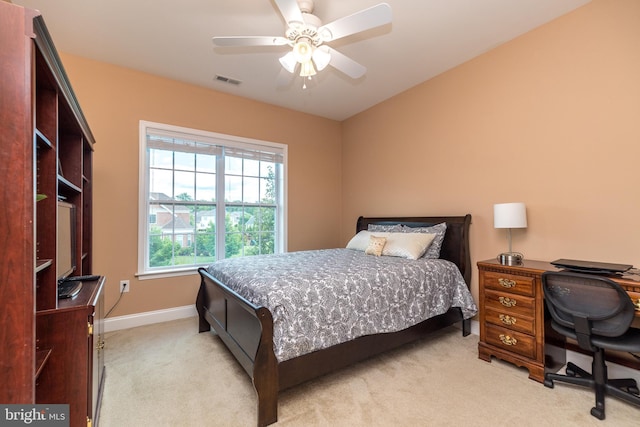 bedroom with ceiling fan, light colored carpet, visible vents, and baseboards