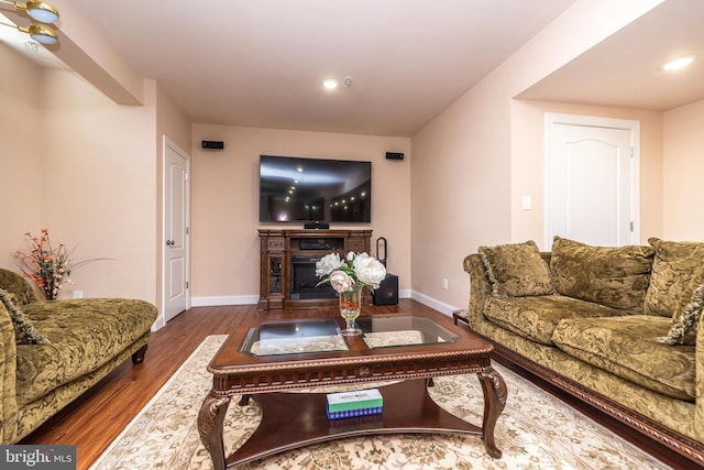 living room featuring recessed lighting, a fireplace, baseboards, and wood finished floors