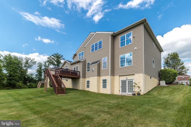 back of property with stairway, a lawn, a deck, and stucco siding