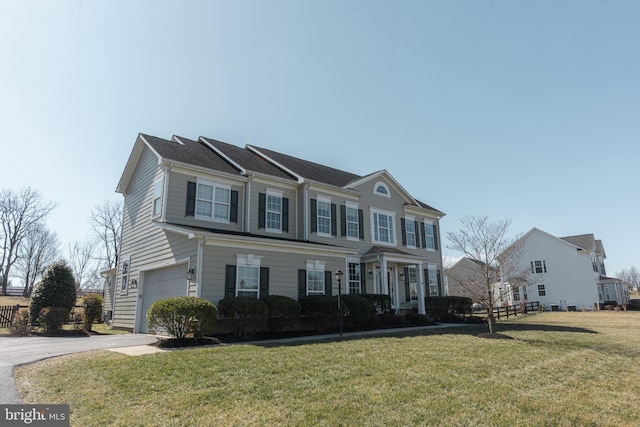 view of front of house with concrete driveway, an attached garage, and a front lawn