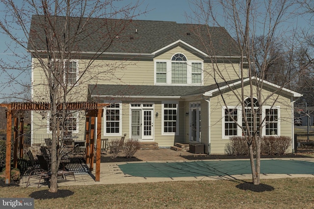 back of property with entry steps, a pergola, a patio, and roof with shingles