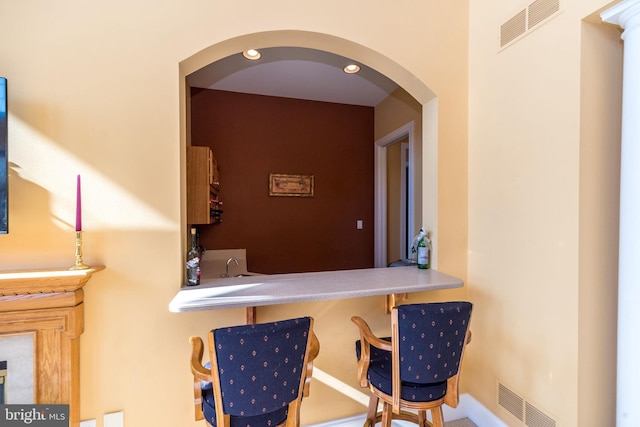 bar with arched walkways, recessed lighting, visible vents, and a sink