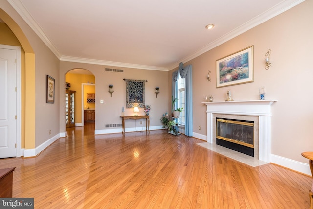 unfurnished living room featuring arched walkways, visible vents, and light wood finished floors