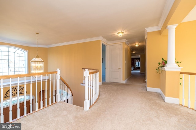 corridor with an upstairs landing, ornamental molding, carpet floors, baseboards, and ornate columns