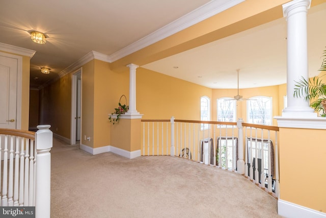 hall featuring baseboards, ornate columns, crown molding, carpet flooring, and an upstairs landing