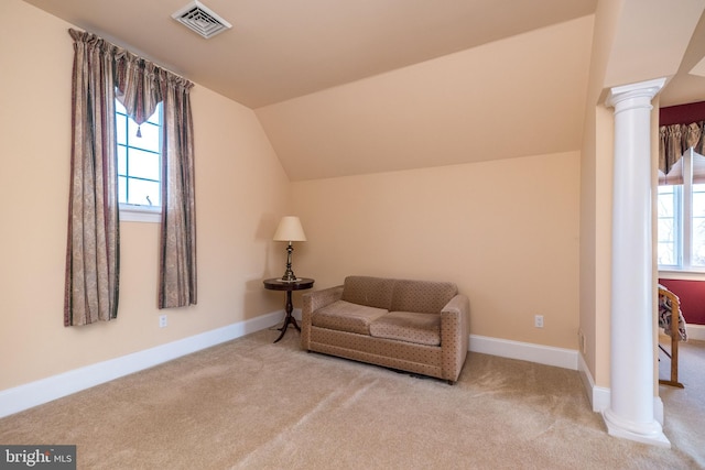 sitting room featuring visible vents, carpet flooring, decorative columns, baseboards, and vaulted ceiling