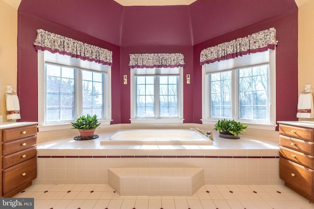 full bath with tile patterned floors, a wealth of natural light, and a bath