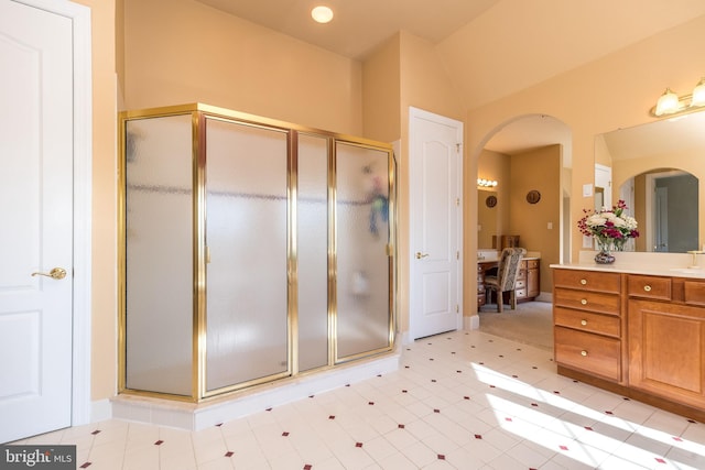 bathroom with vanity, a shower stall, and lofted ceiling