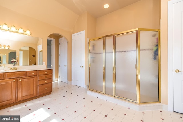 bathroom featuring a stall shower, vanity, and vaulted ceiling