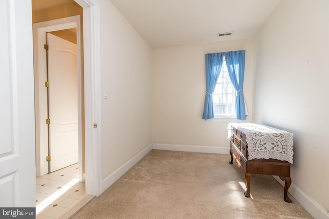 living area featuring visible vents, baseboards, and light carpet