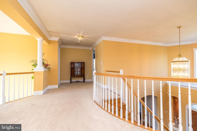 hallway featuring a chandelier, an upstairs landing, ornamental molding, and carpet flooring