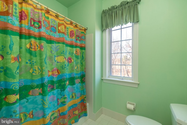 bathroom featuring tile patterned floors, a shower with curtain, baseboards, and toilet